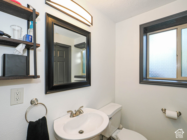 3308 Willow Ridge Road Salt Lake City, UT 84121 - Photo 57 of 59 Pedestal sink with brushed nickel faucet, framed mirror with integrated lighting, built-in shelving, and frosted glass window