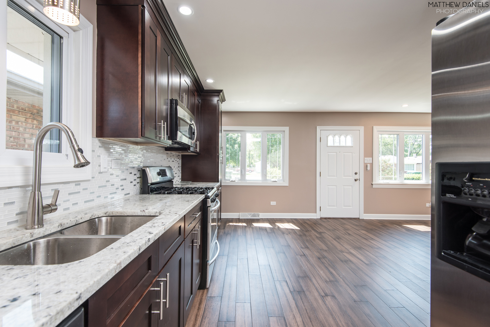 5208 State Road Burbank, IL 60459 - Photo 5 of 21 a kitchen with granite countertop a sink wooden floor and stainless steel appliances