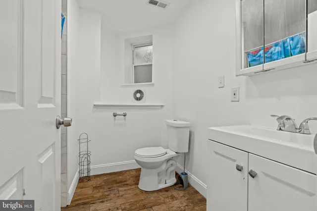a bathroom with a toilet sink and mirror