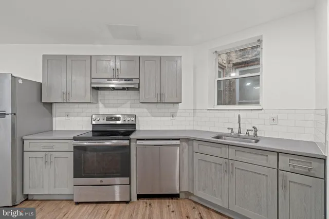 a kitchen with a sink stove and cabinets