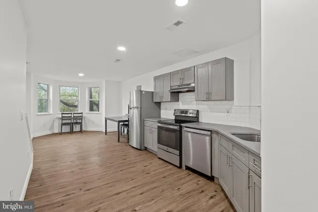 a kitchen with a sink cabinets and wooden floor