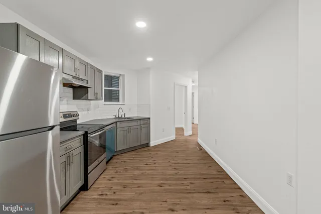 a kitchen with stainless steel appliances granite countertop a refrigerator a stove top oven a sink and dishwasher