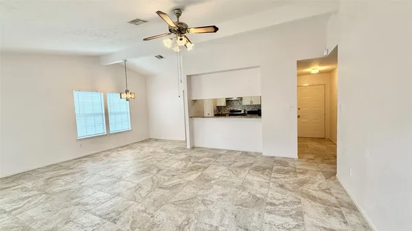 a view of a kitchen with a refrigerator and a ceiling fan