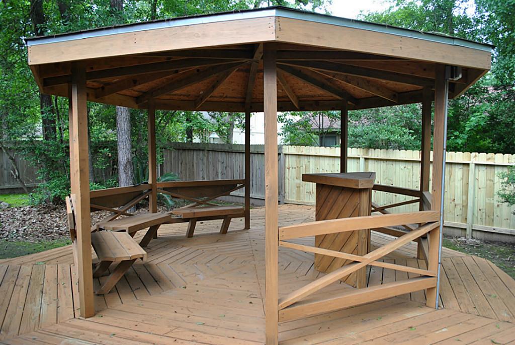 18 Dellforest Court Spring, TX 77381 - Photo 42 of 42 a view of a roof deck with table and chairs under an umbrella with a wooden floor