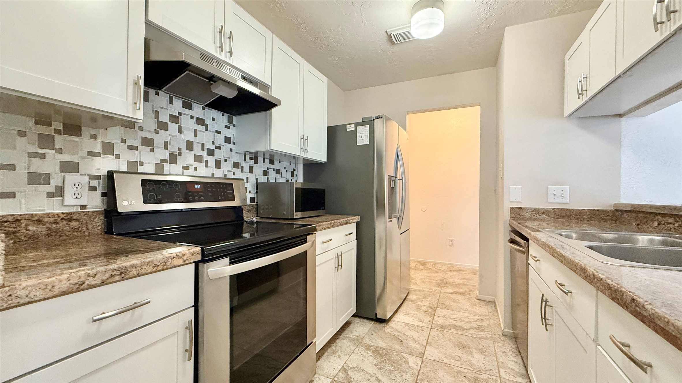 18 Dellforest Court Spring, TX 77381 - Photo 7 of 42 a kitchen with stainless steel appliances granite countertop a stove a microwave and a refrigerator