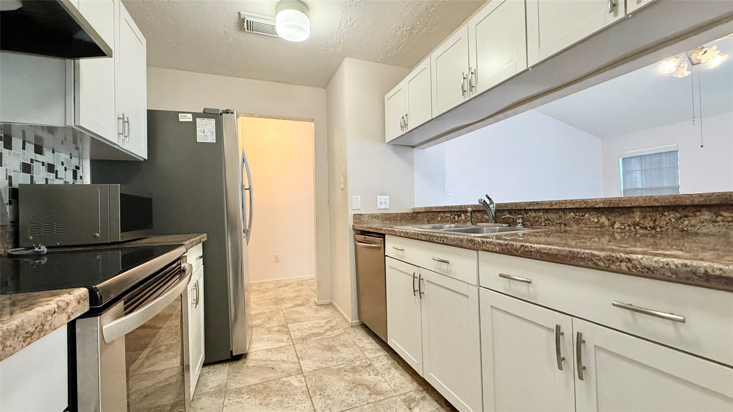 18 Dellforest Court Spring, TX 77381 - Photo 8 of 42 a kitchen with granite countertop a sink stove and refrigerator