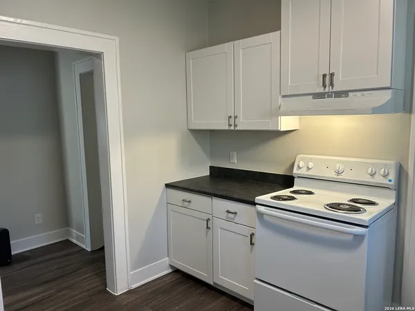 a kitchen with white cabinets and appliances