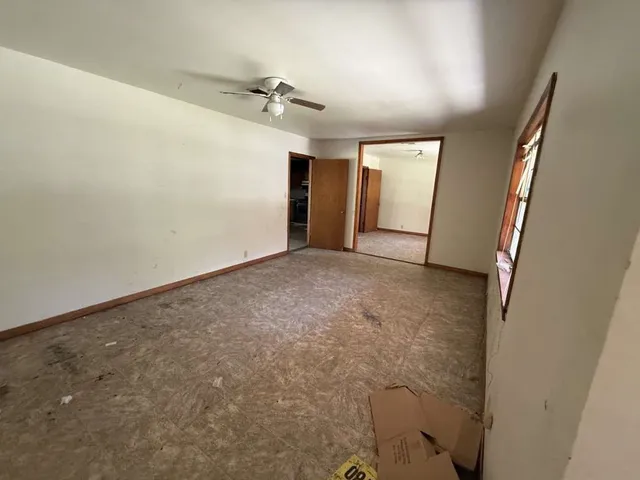 en empty room with windows and cabinet