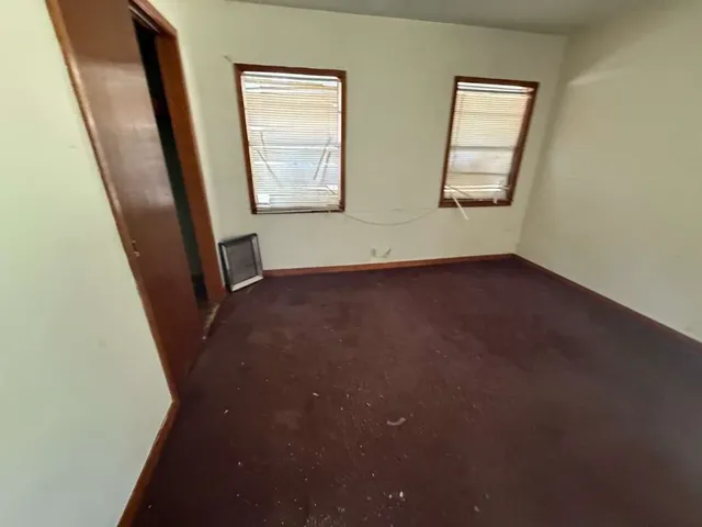 an empty room with windows and closet