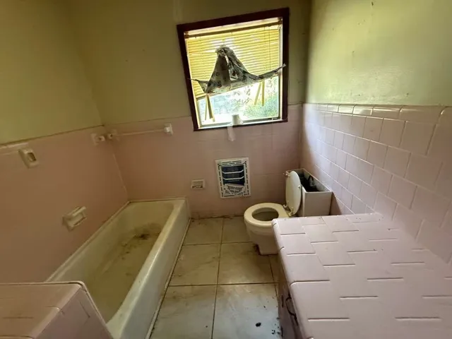 a bathroom with a bathtub and window
