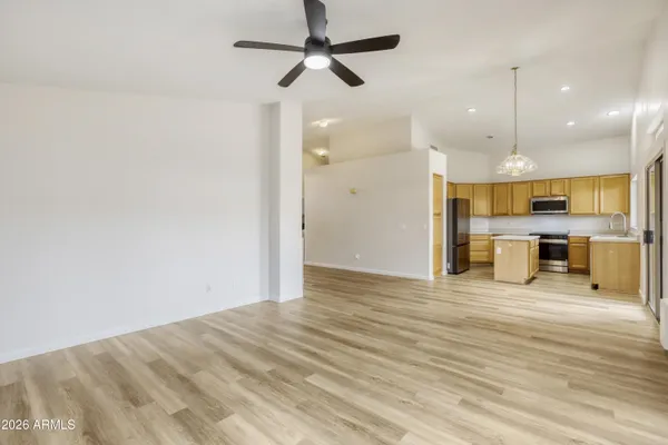 a view of a kitchen with wooden floor and a ceiling fan