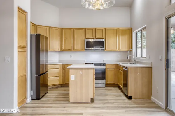 a kitchen with stainless steel appliances granite countertop a refrigerator a stove top oven and a sink with granite countertops