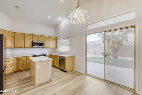 a kitchen with stainless steel appliances granite countertop a stove top oven a sink dishwasher a refrigerator and cabinets with wooden floor