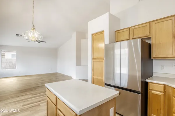 a view of a kitchen with a refrigerator and wooden floor