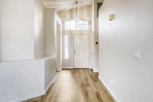 a view of a hallway with wooden floor and staircase