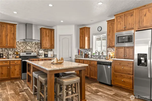 a kitchen with stainless steel appliances granite countertop a sink stove and refrigerator