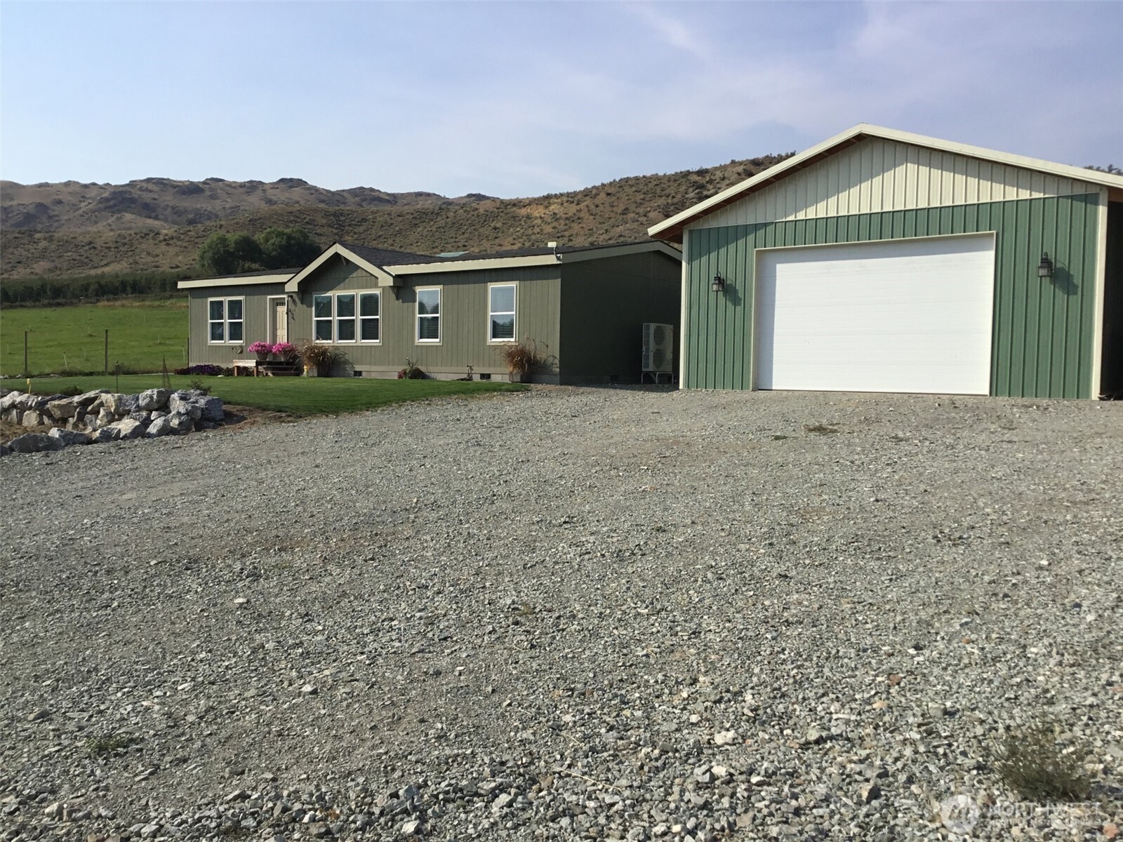 60 Alvarado Road Tonasket, WA 98855 - Photo 2 of 36 a front view of a house with a yard and garage