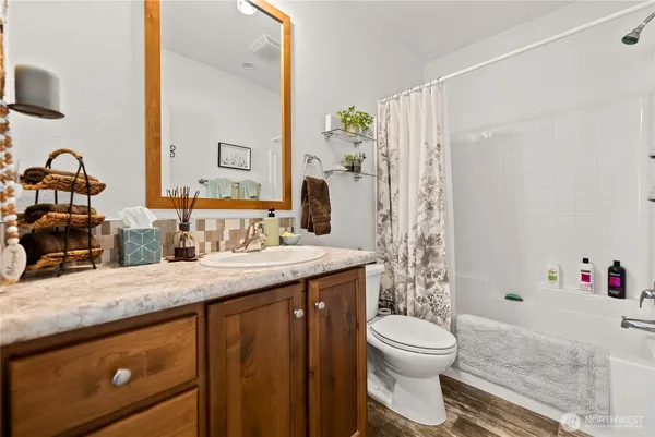 a bathroom with a granite countertop sink toilet and shower