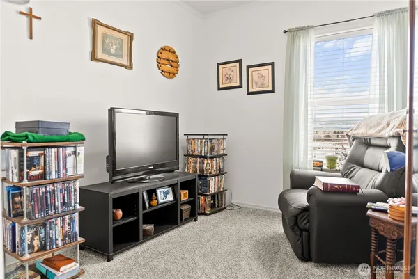 a living room with furniture a flat screen tv and a window