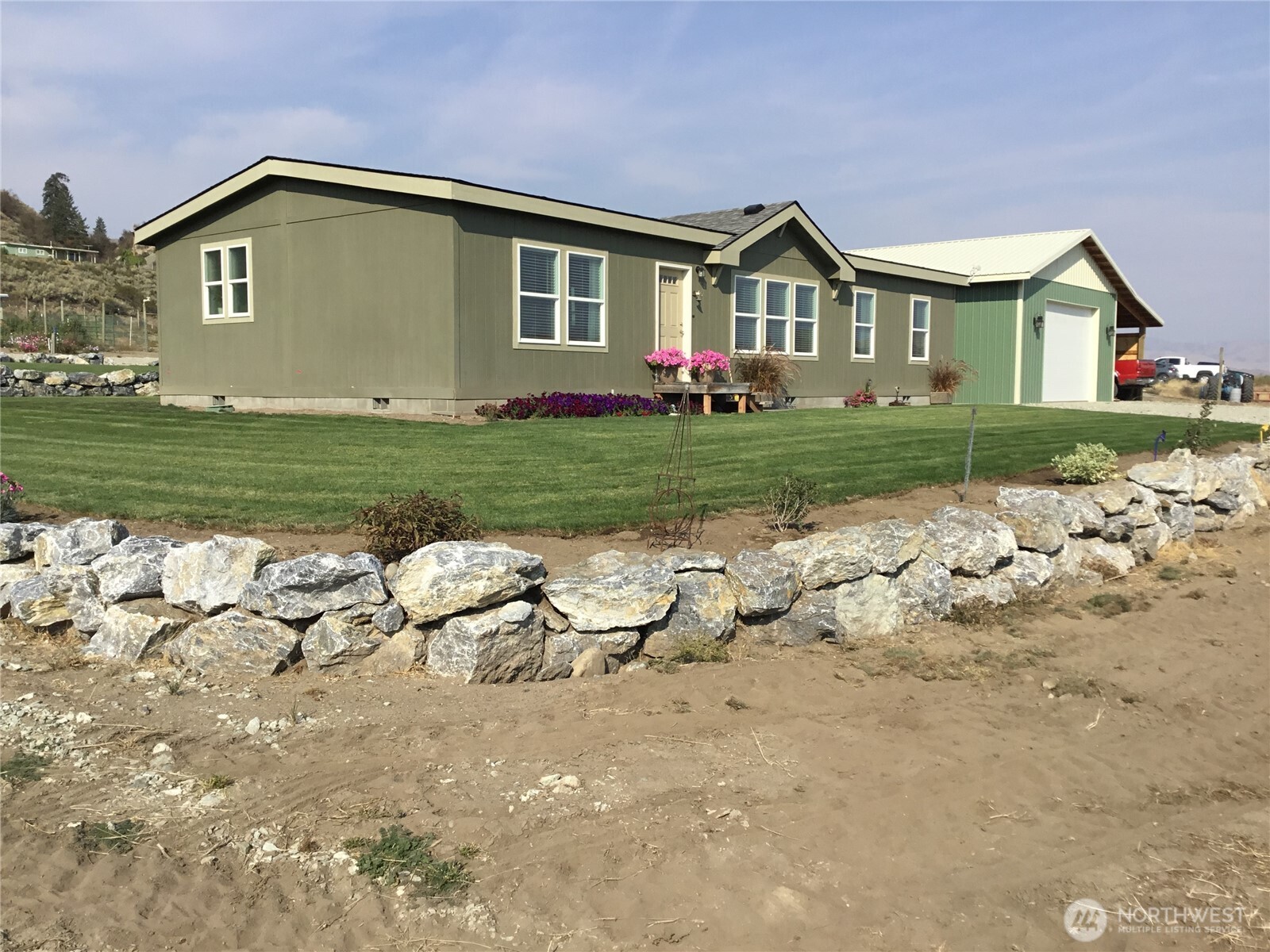 60 Alvarado Road Tonasket, WA 98855 - Photo 35 of 36 a front view of a house with a yard and garage
