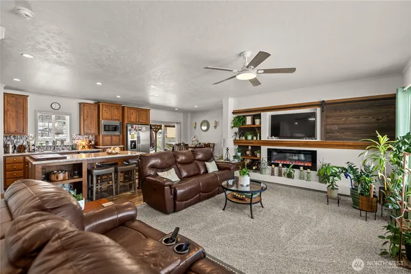 a living room with furniture kitchen view and a window