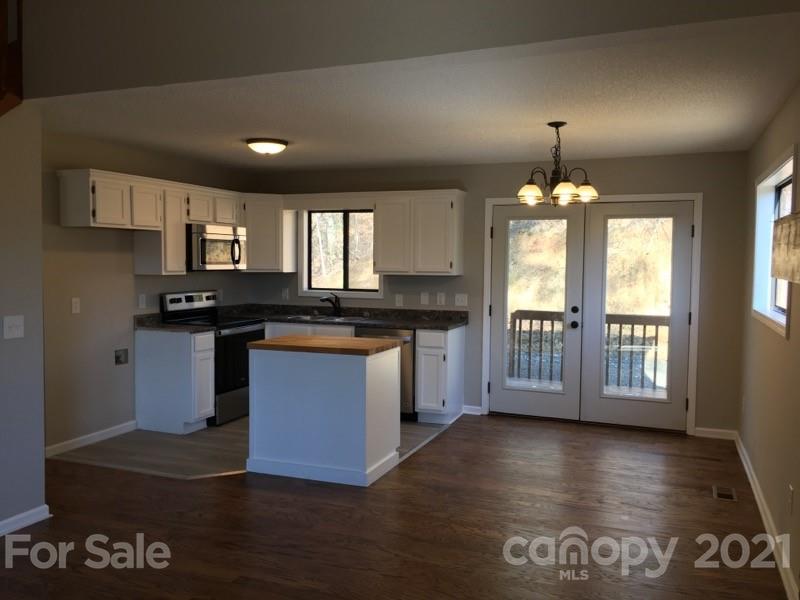 888 Rustic Heights Road Waynesville, NC 28785 - Photo 8 of 25 a kitchen with granite countertop a stove a sink and a refrigerator