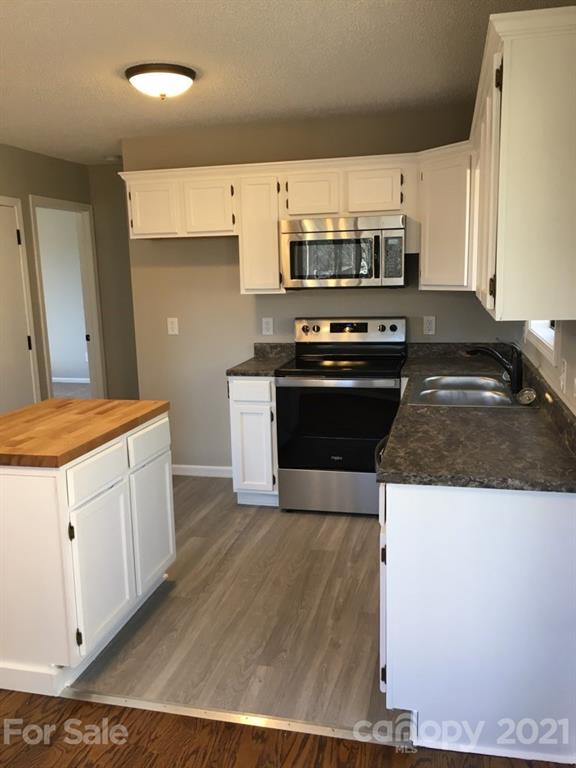 888 Rustic Heights Road Waynesville, NC 28785 - Photo 9 of 25 a kitchen with stainless steel appliances a stove a sink and a refrigerator