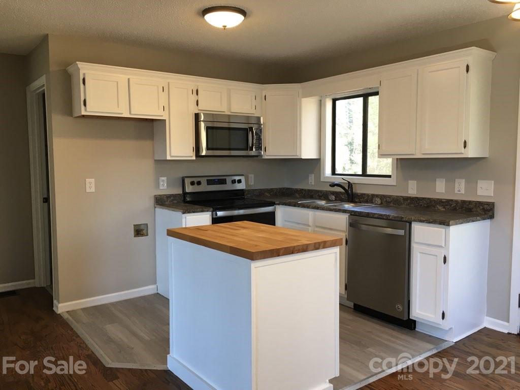 888 Rustic Heights Road Waynesville, NC 28785 - Photo 10 of 25 a kitchen with stainless steel appliances granite countertop a stove a sink and a microwave