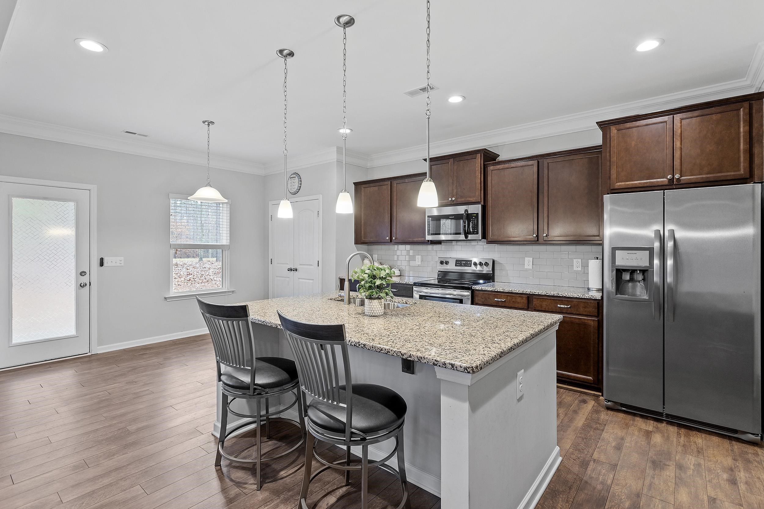 306 Springhill Lane Garner, NC 27529 - Photo 16 of 34 a kitchen with a table chairs refrigerator and microwave