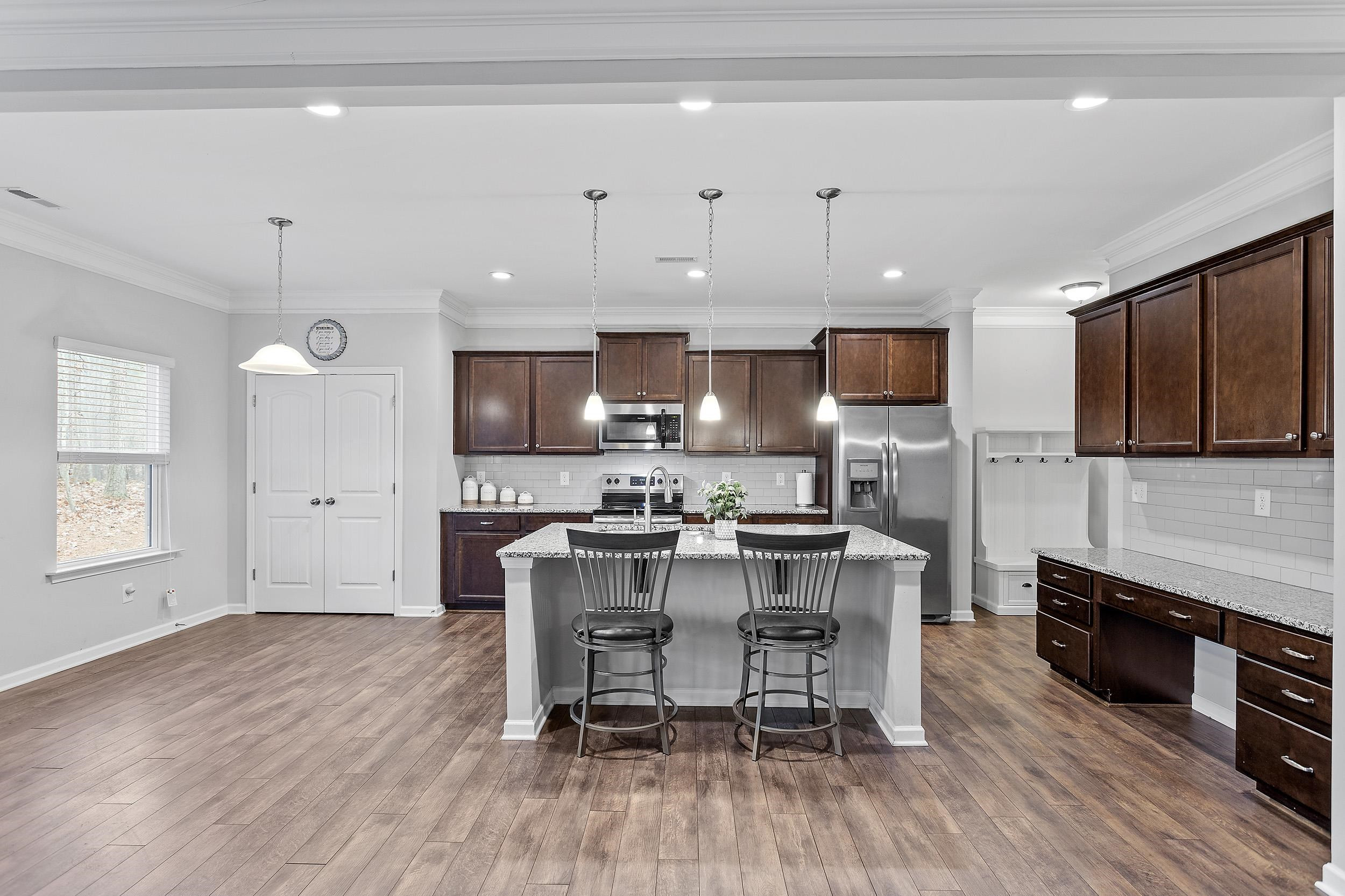 306 Springhill Lane Garner, NC 27529 - Photo 19 of 34 a kitchen with stainless steel appliances a dining table chairs microwave and cabinets