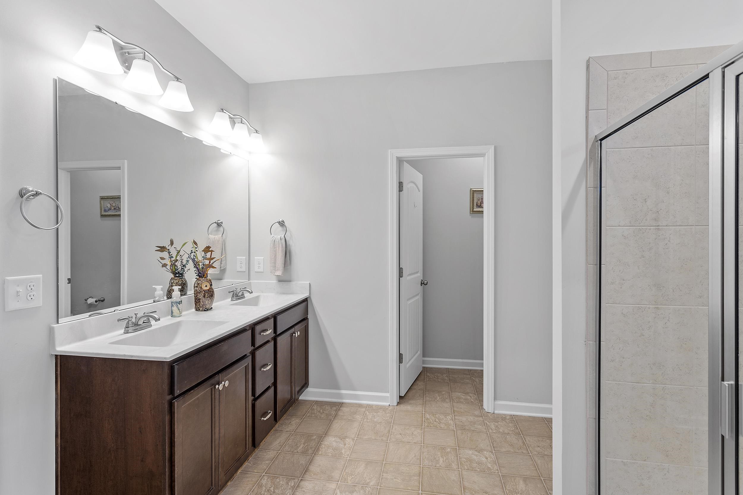 306 Springhill Lane Garner, NC 27529 - Photo 26 of 34 a bathroom with a double vanity sink and a mirror