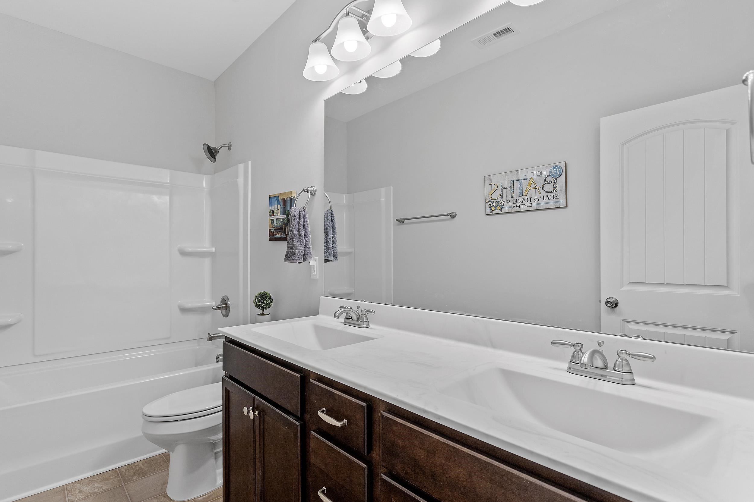306 Springhill Lane Garner, NC 27529 - Photo 33 of 34 a bathroom with a sink a toilet a mirror and shower