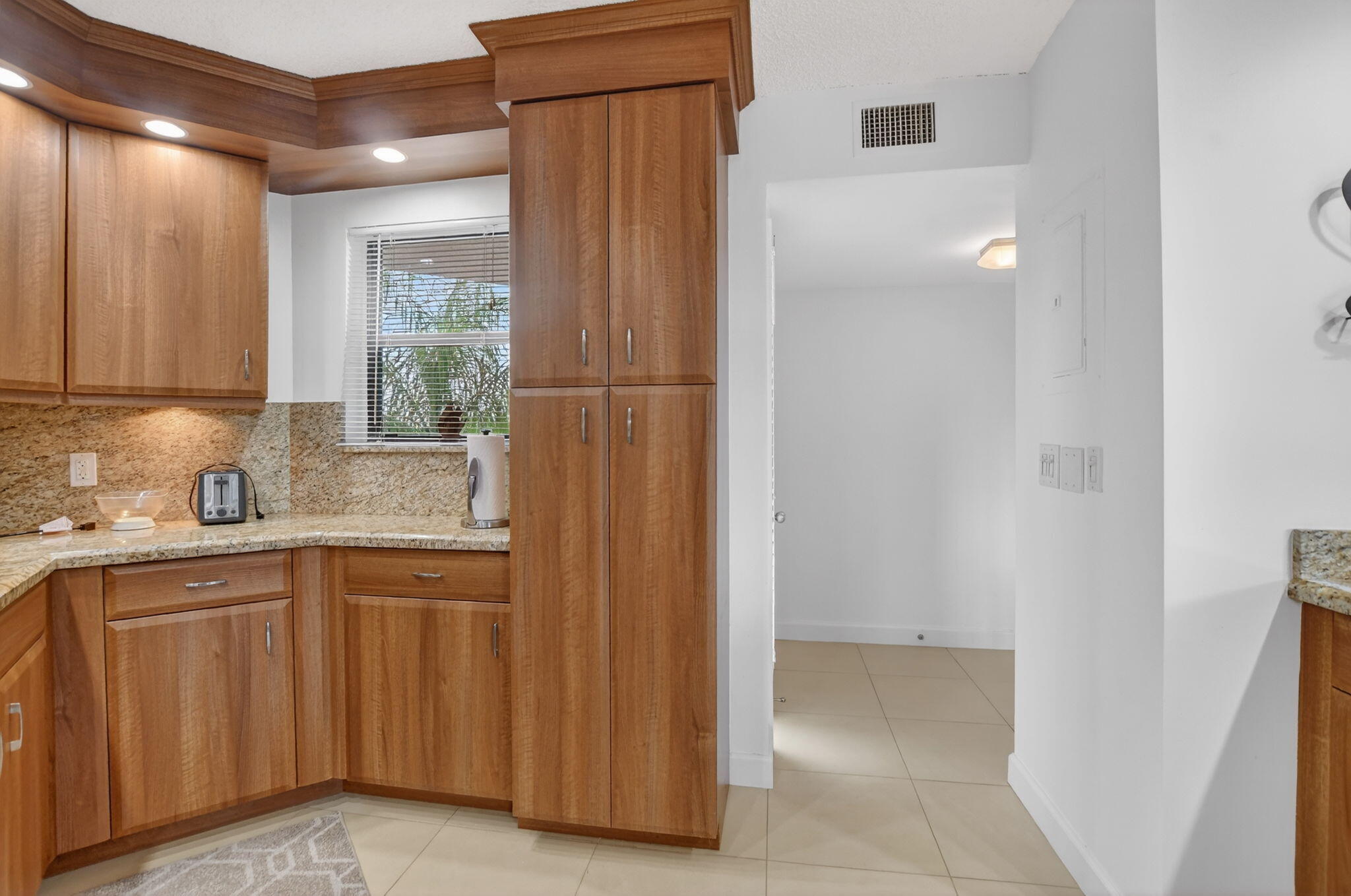 5851 Camino Del Sol, Unit 402 Boca Raton, FL 33433 - Photo 14 of 40 a kitchen with white cabinets and sink