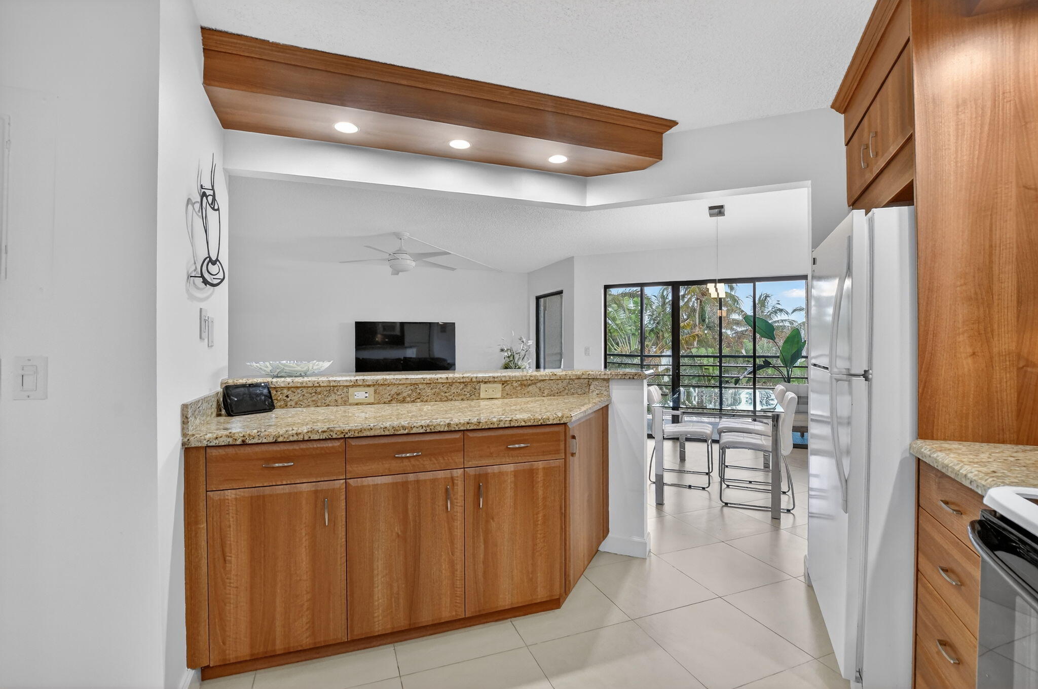 5851 Camino Del Sol, Unit 402 Boca Raton, FL 33433 - Photo 15 of 40 a dining hall with granite countertop a stove and a sink