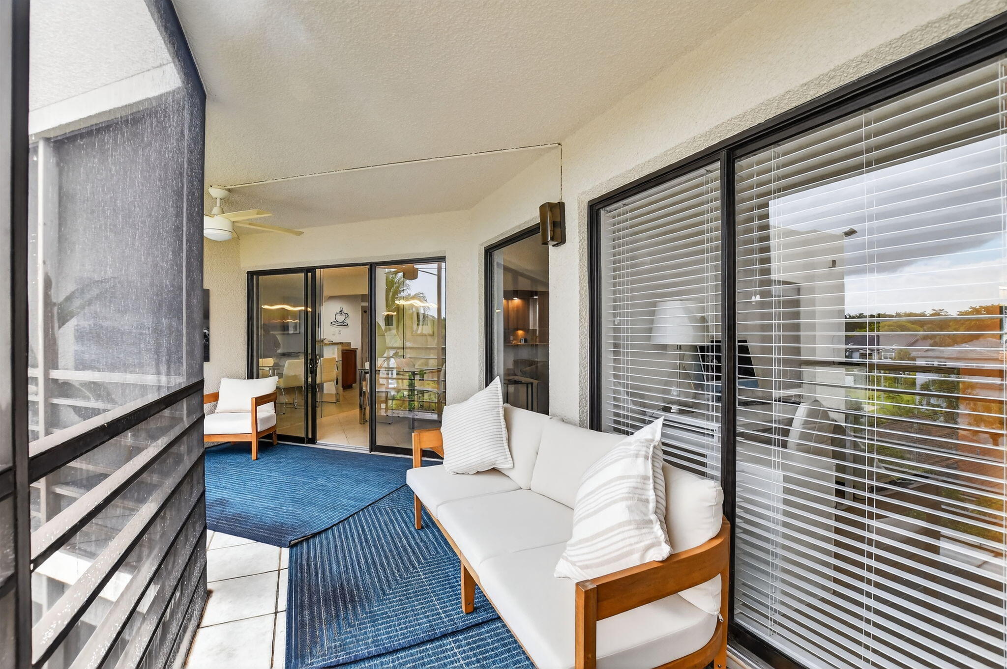 5851 Camino Del Sol, Unit 402 Boca Raton, FL 33433 - Photo 19 of 40 a view of a balcony with couch and wooden floor