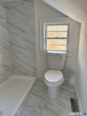 a bathroom with a toilet and a bathtub