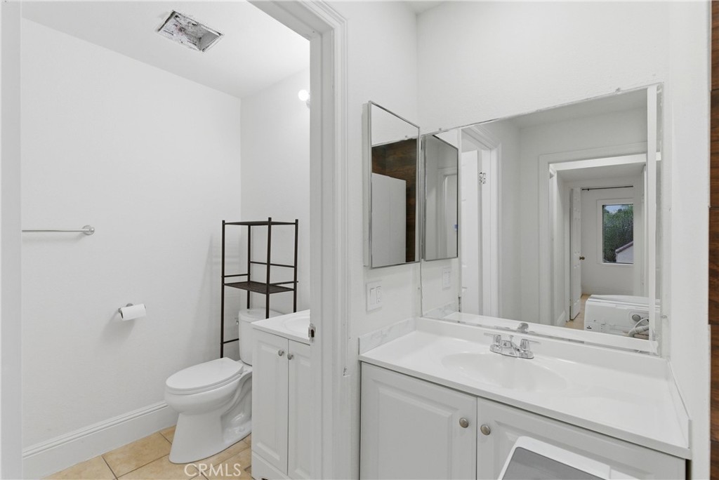 600 West 3rd Street, Unit A210 Santa Ana, CA 92701 - Photo 16 of 30 a bathroom with a toilet sink vanity and mirror