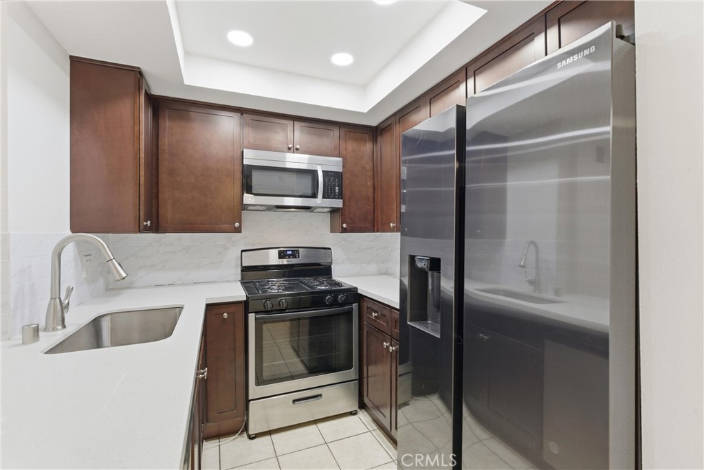 600 West 3rd Street, Unit A210 Santa Ana, CA 92701 - Photo 6 of 30 a kitchen with stainless steel appliances granite countertop a refrigerator and a sink