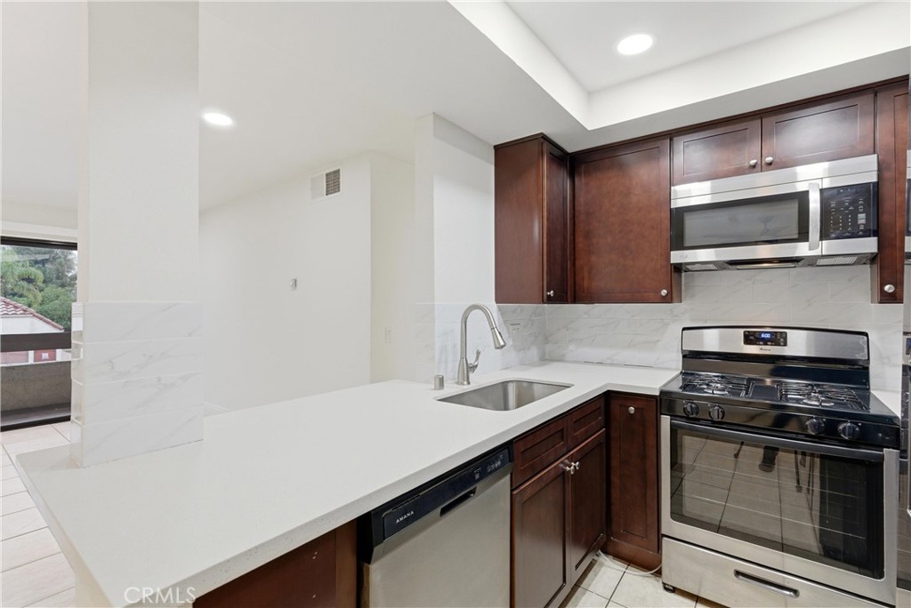 600 West 3rd Street, Unit A210 Santa Ana, CA 92701 - Photo 8 of 30 a kitchen with stainless steel appliances a stove microwave and sink