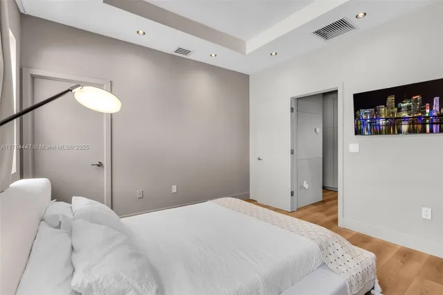 a bedroom with a bed and a painting on the wall