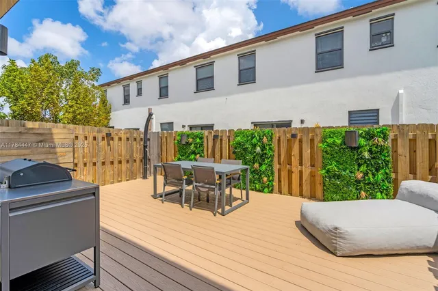 a view of a patio with table and chairs with wooden floor and fence