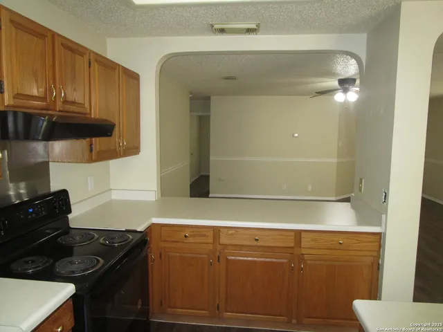 a kitchen with granite countertop white cabinets and black appliances