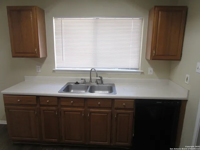 a kitchen with a sink cabinets and window
