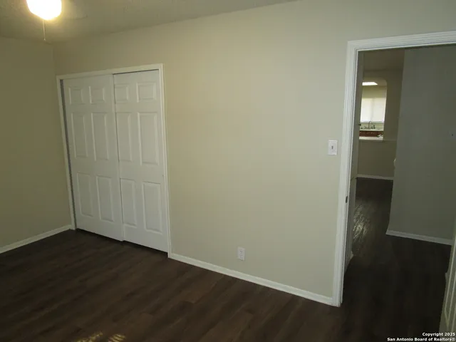 an empty room with wooden floor and closet