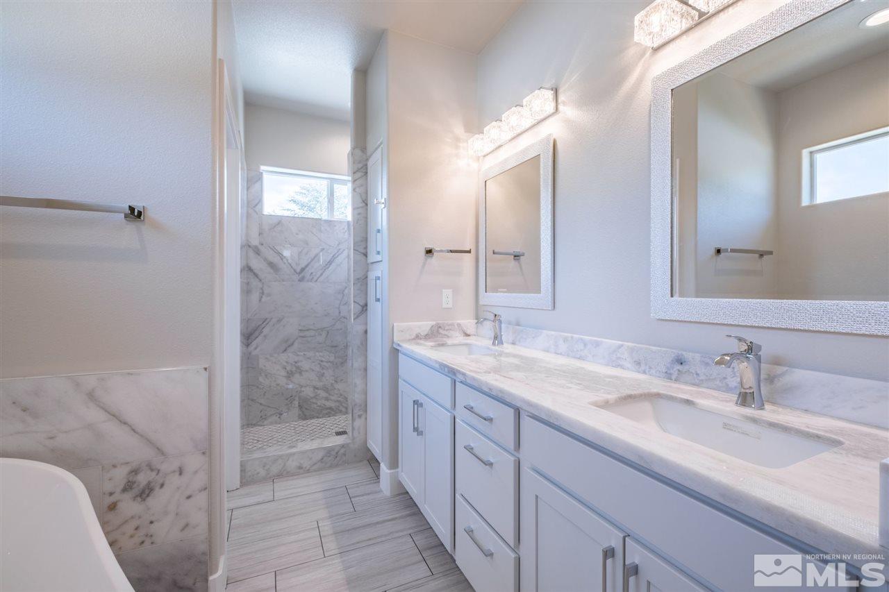 1605 Elizabeth Street Reno, NV 89509 - Photo 14 of 25 a spacious bathroom with a granite countertop sink mirror and a shower