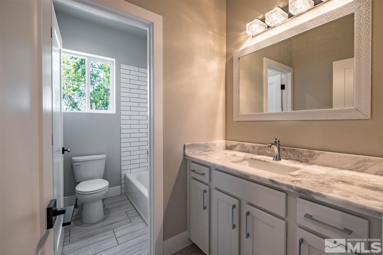 1605 Elizabeth Street Reno, NV 89509 - Photo 17 of 25 a bathroom with a granite countertop toilet a sink and a mirror