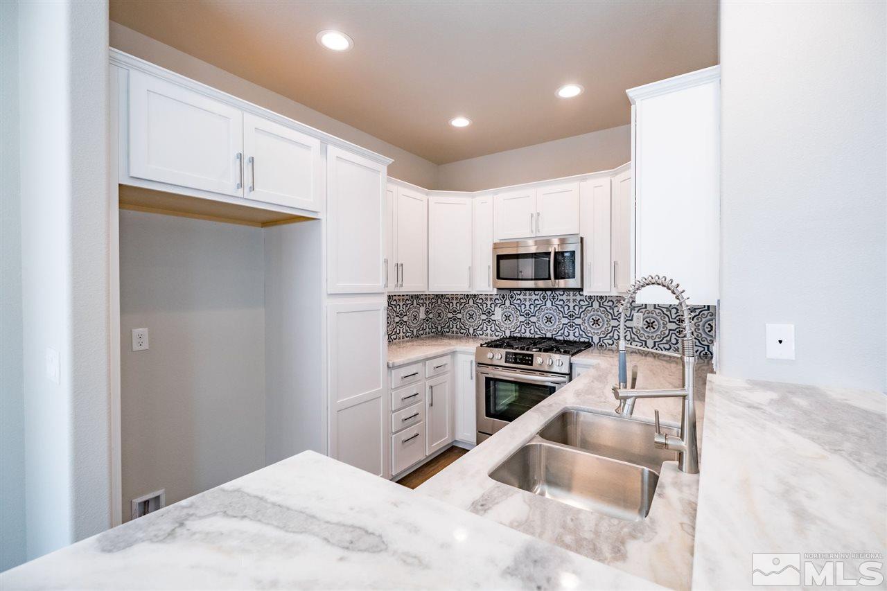 1605 Elizabeth Street Reno, NV 89509 - Photo 7 of 25 a kitchen with granite countertop a stove top oven and cabinets