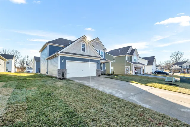a view of a big house with a big yard and large tree