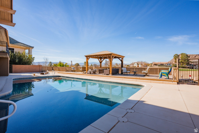 980 Cactus Circle St. George, UT 84790 - Photo 41 of 77 View of swimming pool with patio surround, a fenced backyard, a gazebo, and a mountain view