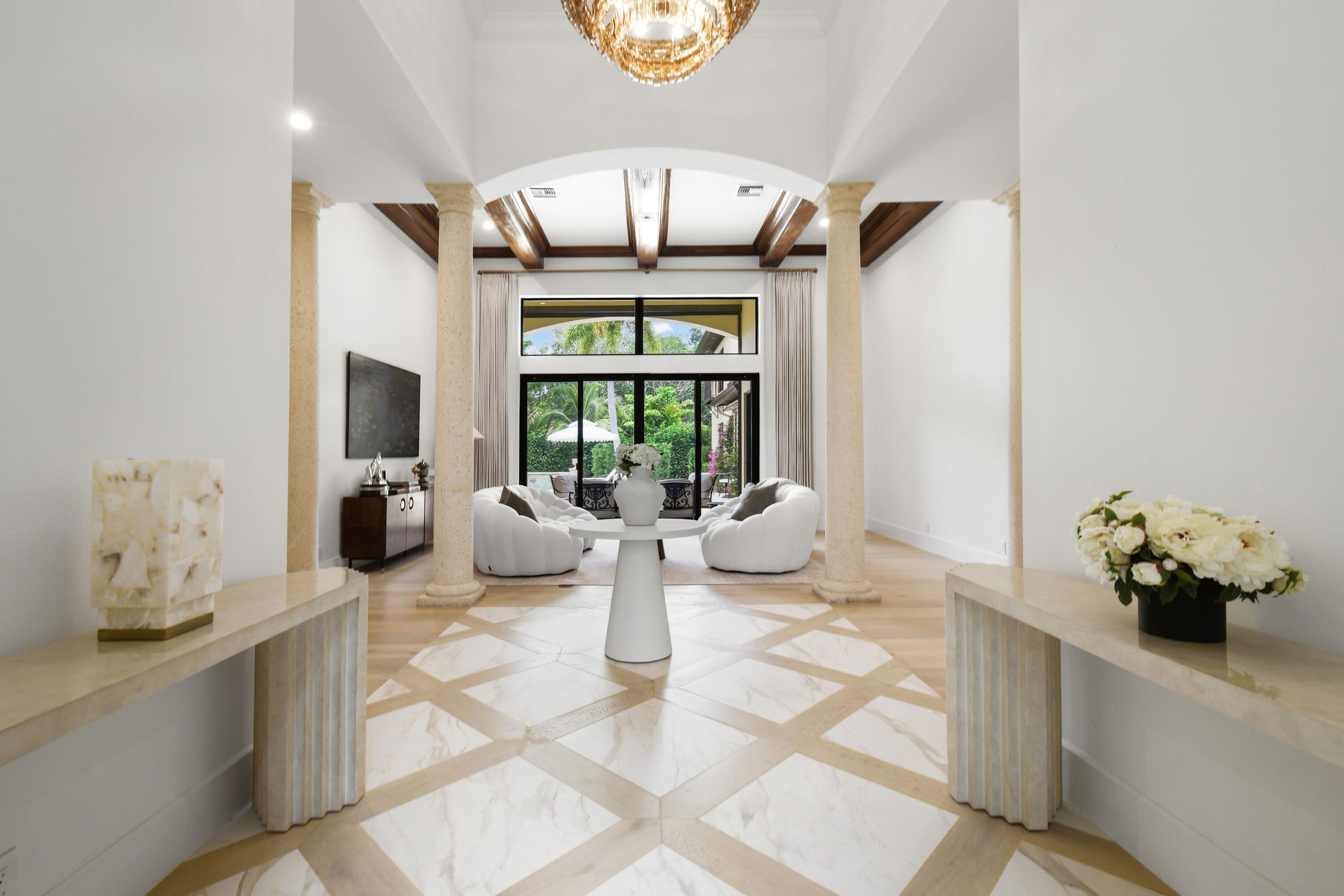 a view of a dining room with furniture a chandelier and wooden floor